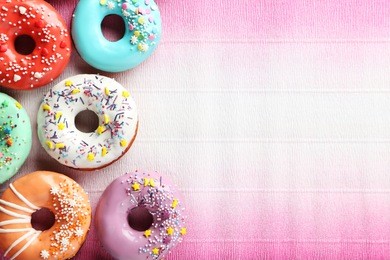tasty donuts with sprinkles on paper background