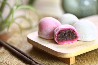japanese dessert : red bean mochi served with japanese matcha green tea. red bean daifuku and taro daifuku on wood chop, selective focus and toned image.