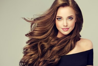 brunette  girl with long  and   shiny wavy hair .  beautiful  model with curly hairstyle .