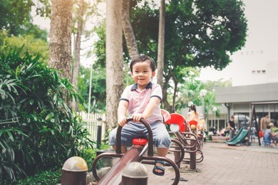 cute little asian boy in a park on a nice day outdoors