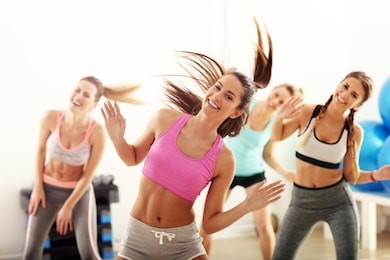 group of happy people with coach dancing in gym