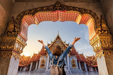 women tourists wear jacket jeans at wat benchamabophit or the marble temple, the beautiful and famous temple in bangkok, thailand.