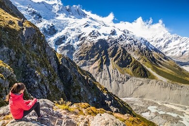 new zealand woman tourist lifestyle hiking in mountains relaxing looking at view of mt cook. alps in south island.