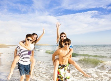 happy young group  running on the beach