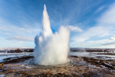geyser strokkur eruption on winter day with steam