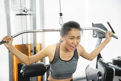 asian woman in sportswear exercising with exercise machine at the gym.