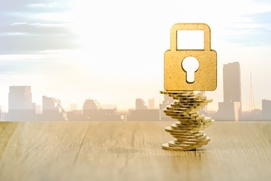 wooden security lock on stack of coins with cityscape. financial, security concept.