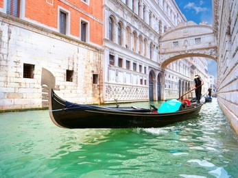 traditional gondolas passing over bridge of sighs in venice, italy
