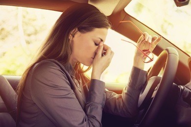 business woman having headache taking off her glasses has to make a stop after driving car in traffic jam on rush hour. exhausted, overworked driver concept.