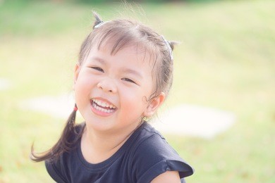 asian sweet little girl outdoors in the park.portrait of happy smiling cute little girl child outdoors in summer day.