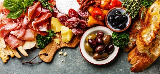 italian food ingredients ham, salami, parmesan, olives, bread sticks