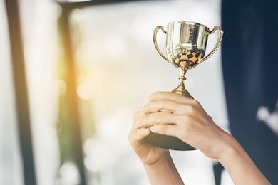 teenage girls' hands are holding trophies, congratulations on success.conception of victory in the competition.focus on the trophy