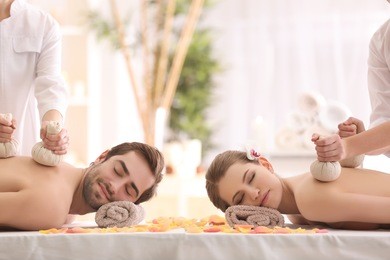 young happy couple having massage in spa salon