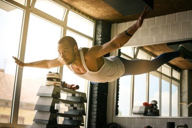 young athlete man workout in healthy club. athlete levitates above ground during training.