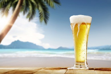 cold beer on desk and background of summer beach with palm 