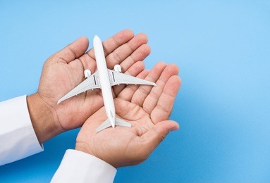 hands support airplane model, travel insurance concept.