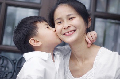 asian boy kissing his mum