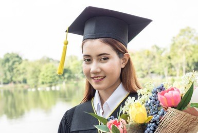 happy graduate  flower bouquet in hand with in the garden
