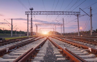 modern railway station at night in europe. industrial landscape with railroad junction, purple sky and sunset. railway platform in twilight. railway background. heavy industry. freight transportation