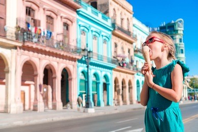 adorable little girl eating ice-cream in popular area in old havana, cuba. portrait of cutiest kid outdoors on a street of havana