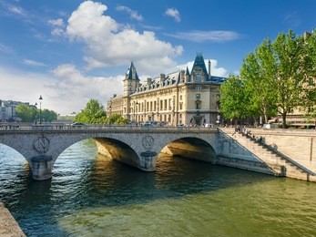 southern facade of the palace of justice with towers, river seine, her embankment and bridge in the foreground in paris