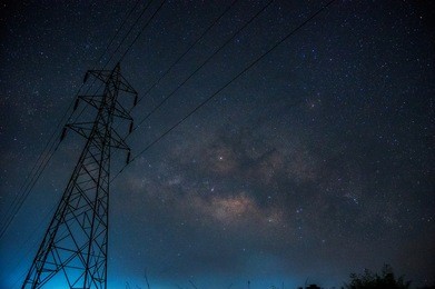 detail from the milky way on sky with  silhouette high voltage pole, long speed exposure.