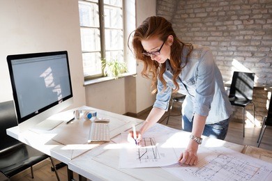 female designer in office working on architects project