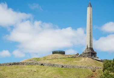 the obelisk monument on the top of one tree hill in auckland, new zealand.
