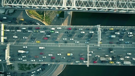 aerial top down view of traffic jam on a car bridge and moving train