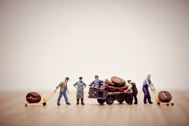 miniature workers loading coffee beans on truck.
