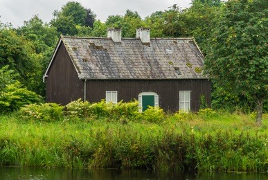 small house surrounded by green grass and woods, outside enniskillen, northern ireland.