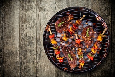 top view of fresh meat and vegetable on grill placed on wooden floor. barbecue, grill and food concept