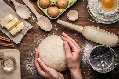 hands working with dough preparation recipe bread, pizza, pie or samsa making ingridients, food flat lay on kitchen table background. butter, milk, yeast, flour, eggs, sugar pastry or bakery cooking