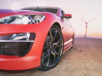 the image in front of the sports car scene behind as the sun going down with wind turbines in the back. 3d render.
