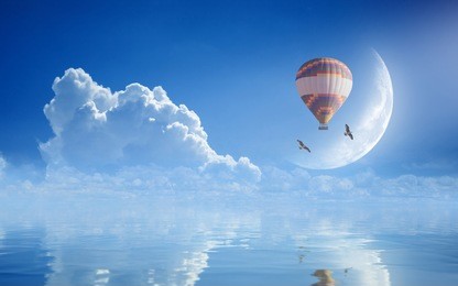 idyllic heavenly picture - colorful hot air balloon, two seagulls flying in blue sky with white clouds and crescent above serene sea. dream come true concept.elements of this image furnished by nasa