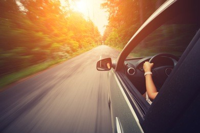 young beautiful woman driving car at sunny day - outside view