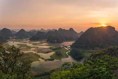 sunset over the karst mountains near puzhehei in yunnan province, china.