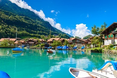 boats in bay of village iseltwald at lake brienz - beautiful lake in the alps at interlaken, switzerland