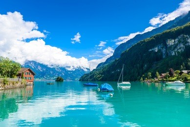 boats in bay of village iseltwald at lake brienz - beautiful lake in the alps at interlaken, switzerland