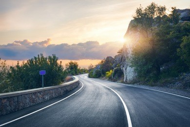 mountain road. landscape with rocks, sunny sky with clouds and beautiful asphalt road in the evening in summer. vintage toning. travel background. highway in mountains. transportation