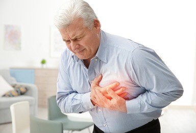 heart attack concept. senior man suffering from chest pain indoor