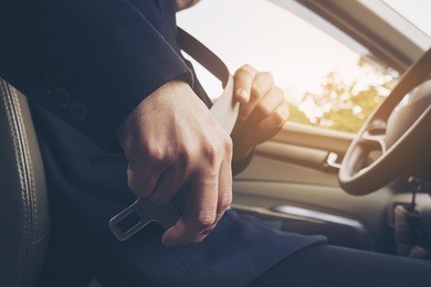 man putting car seat belt before driving, close up at belt buckle, safe drive concept