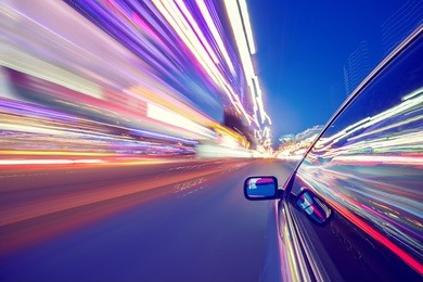 view from side of car moving in a night city, blured road with lights with car on high speed. concept rapid rhythm of a modern city.