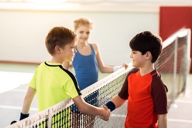 happy children ending sport competition by handshake