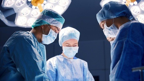 surgery, medicine and people concept - group of surgeons at operation in operating room at hospital