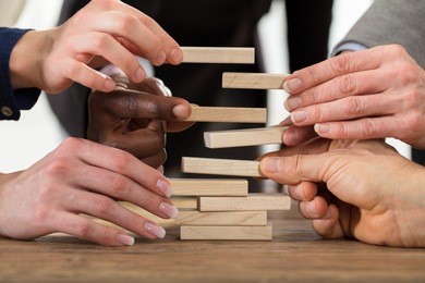 close-up of businesspeople's hand stacking wooden blocks