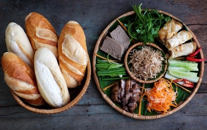 famous vietnamese food is banh mi thit, popular street food from bread stuffed with raw material: pork, ham, pate, egg and fresh herbs as scallions, coriander, carrot, cucumber, chilli.