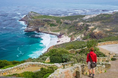 tourist hiking at cape point, looking at view of cape of good hope and dias beach, scenic travel destination in south africa. table mountain national park, cape peninsula.