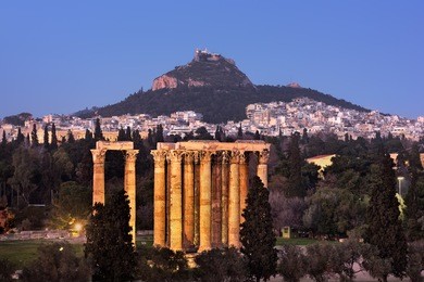 view of the temple of olympian zeus and mount lycabettus in the evening, athens, greece