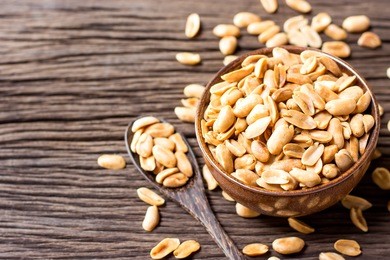 roasted peanuts, salt, put in a cup. brown was placed on the wooden floor.